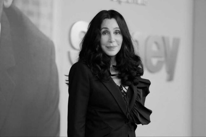 shutterstock_2244803067-modified.jpg Cher with dark hair smiling.