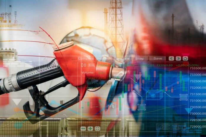 shutterstock_2252977851.jpg Gas pump with financial data overlay and oil refinery in the background