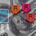 Mortgage Demand CLIFF-Dive Shocks Lenders Colorful house icons on a background of hundred dollar bills with a downward trend graph