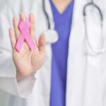 US Breast Cancer Victory: Death Rates Plunge 44% A healthcare professional holding a pink ribbon in their hand