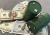 Two green barrels placed on a pile of hundred dollar bills