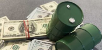 Two green barrels placed on a pile of hundred dollar bills