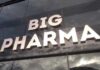 Sign displaying the words BIG PHARMA on a glass building