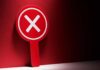 Red sign with a white 'X' symbol against a dark background