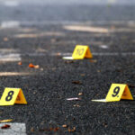 Harmless Prank Turns Deadly Outside Teacher’s Home Yellow evidence markers labeled 8, 9, 10 on pavement.