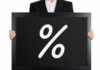 Man holding blackboard with white percent symbol.
