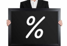 Man holding blackboard with white percent symbol.