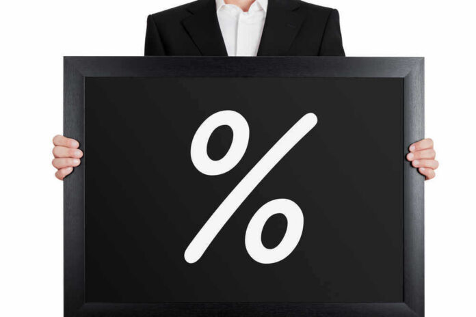 Man holding blackboard with white percent symbol.