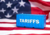 Shipping container reading tariffs on the American flag