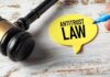 A gavel next to a yellow speech bubble note that reads 'ANTITRUST LAW'