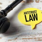 Monopoly Verdict Bombshell — Breakup Looms? A gavel next to a yellow speech bubble note that reads 'ANTITRUST LAW'
