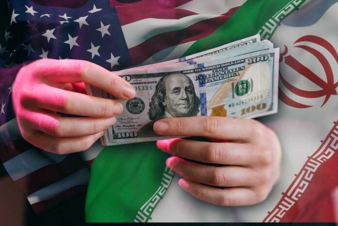 Hands holding a $100 bill with American and Iranian flags in the background