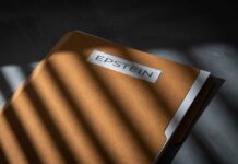 A brown folder with the name 'EPSTEIN' on it, partially illuminated by light and casting shadows