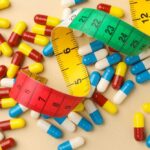 Colorful capsules scattered with a measuring tape