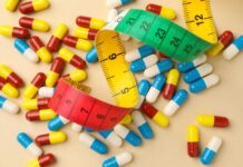 Colorful capsules scattered with a measuring tape