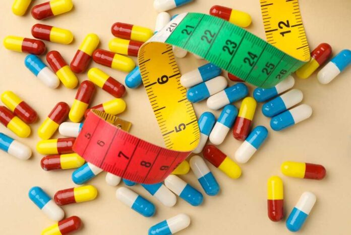 Colorful capsules scattered with a measuring tape