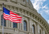 American flag in front of ornate building facade.