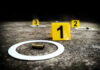 Crime scene with evidence markers and a bullet casing on the ground