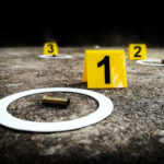 BALLISTIC Nightmare — Evidence Scattered Across Entire Block Crime scene with evidence markers and a bullet casing on the ground