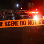 MURDER: Dismembered Teen Found In Tesla Crime scene tape with emergency vehicles in background.