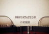 Close-up of a typewriter with the words 'DEPORTATION ORDER' typed on paper