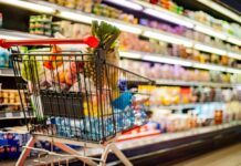 Shock: Memorial Day Cookout Costs Skyrocket! Shopping cart filled with various groceries in a supermarket aisle