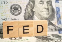 Warsh’s Takeover Stuns Libs! Wooden blocks spelling 'FED' in front of a hundred dollar bill