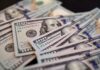Billions Shifting HOME Under Trump Orders Close-up of scattered hundred dollar bills