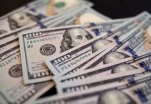 Billions Shifting HOME Under Trump Orders Close-up of scattered hundred dollar bills
