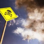 Tragic Night in California: Mystery Deepens Yellow skull and crossbones warning sign against smoky sky