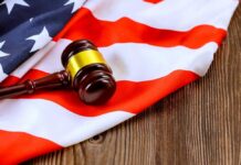 American Flag Blue Sparks Lawsuit Fight A gavel resting on an American flag