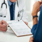 Most-Hated Medical Chokepoint Cracks Open Doctor discussing a medical form with a patient