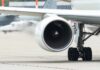 Close-up view of a jet engine and landing gear on an aircraft at an airport