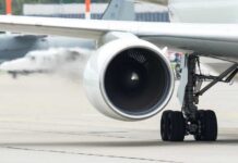Close-up view of a jet engine and landing gear on an aircraft at an airport