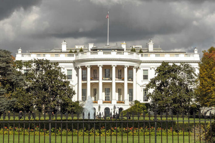 shutterstock_560339335 The White House with dark clouds overhead.