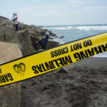 Resort Paradise Turns Deadly Yellow police tape by rocky ocean shore