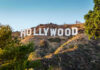 Celebrity Justice, Again: LaBeouf Skates Hollywood Sign on a green hillside, sunny day.