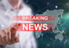 Breaking news graphic over world map background.