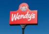 Wendy's restaurant sign against a clear blue sky