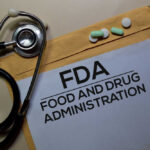 Big Cancer Win For A Select Few? Stethoscope and medication on a folder labeled FDA