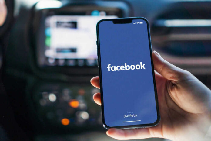 shutterstock_2197003409 Phone displaying Facebook app in a car