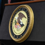 Judge Slams DOJ Power Play Department of Justice seal on a podium.