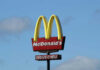 McDonald’s Parking Lot Turns War Zone McDonalds drive-thru sign against a blue sky.