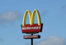 McDonald’s New Trillion-Burger Gambit McDonalds drive-thru sign against a blue sky.