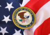 Citizenship Crackdown Explodes — Who’s Next? Department of Justice seal on American flag.