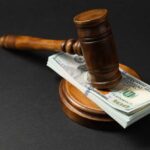 Judge’s gavel resting on a stack of US hundred-dollar bills