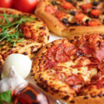 Patriot Pizza Stunt Raises Eyebrows Three pizzas with various toppings and fresh ingredients.