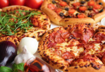 Three pizzas with various toppings and fresh ingredients.
