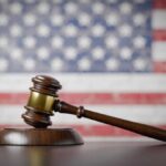 National Citizenship List? Judge Says NO A wooden gavel resting on a sound block with an American flag background