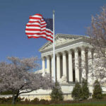 Sotomayor Fumes As Red State Map Survives U.S. Supreme Court building with an American flag and cherry blossom trees